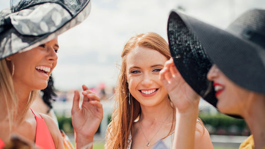 Three ladies with hats at the races