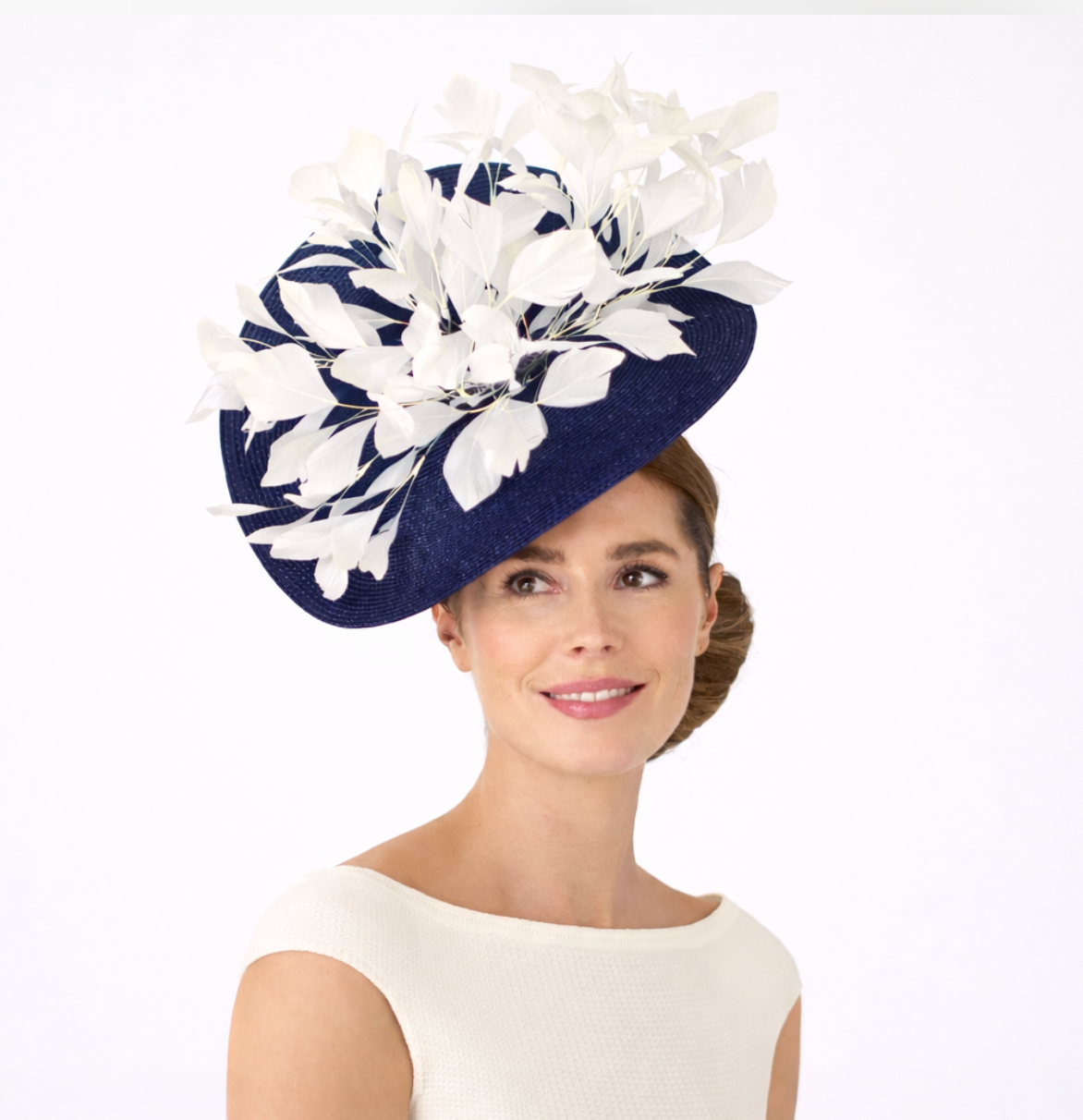 Woman wearing a navy and white floral hat on a white background