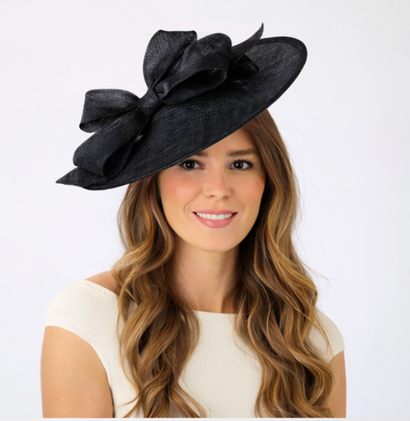 Woman wearing a black decorative hat with a large bow on a white background